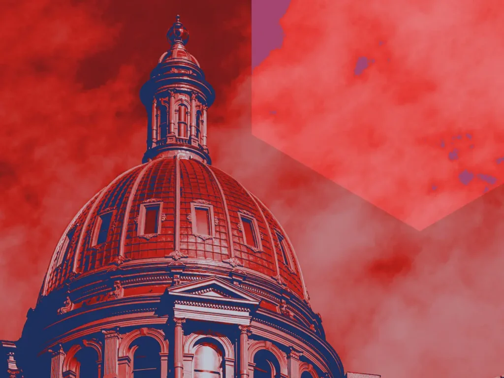 Top of the Colorado State Capitol colored navy and red with a hexagon shape in the sky.