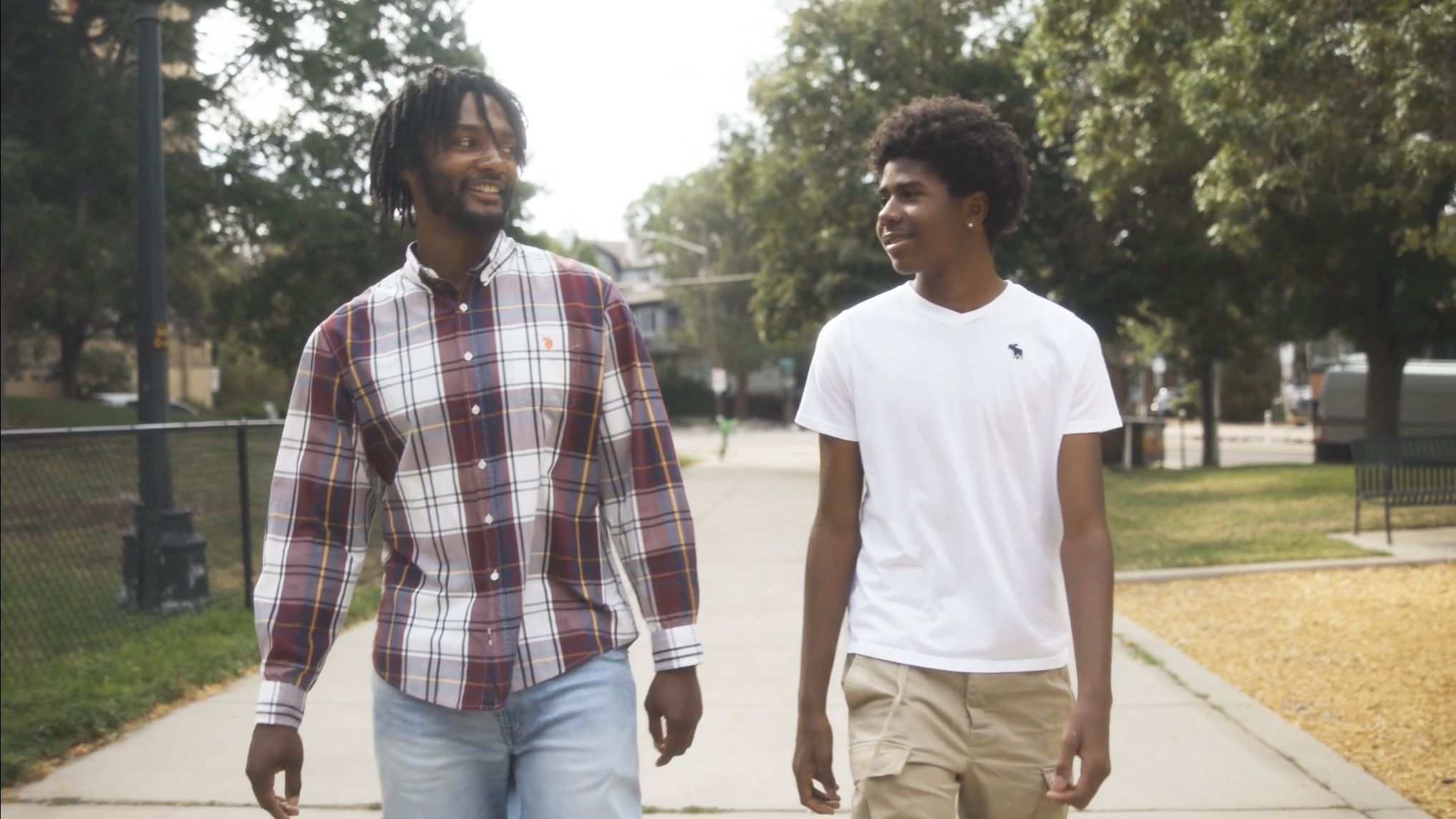 A teenage boy and his CASA take a walk together in a park