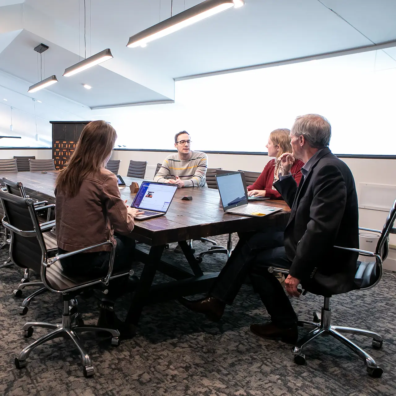 GroundFloor Media team members sit in a conference room discussing a project