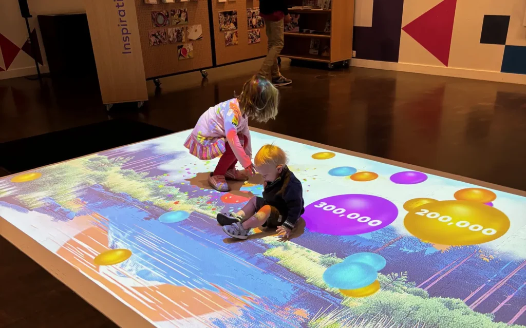 Two children play in the digital learning area of the Denver Art Museum during the Millionth Kid celebration