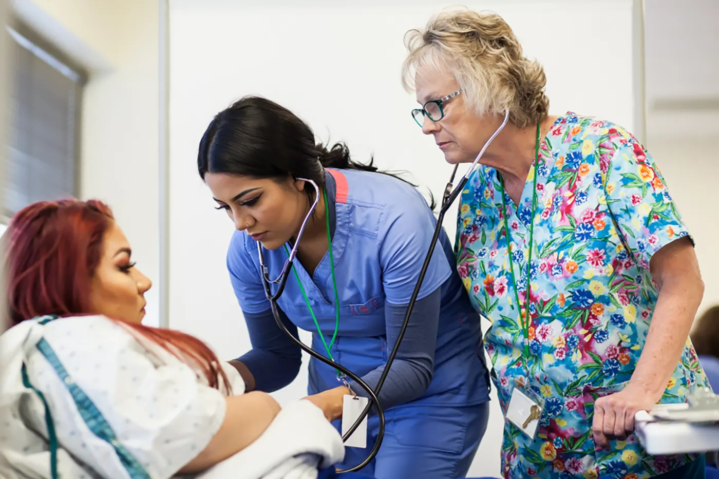 An instructor in the Emily Griffith health sciences program oversees a student tending to a patient 